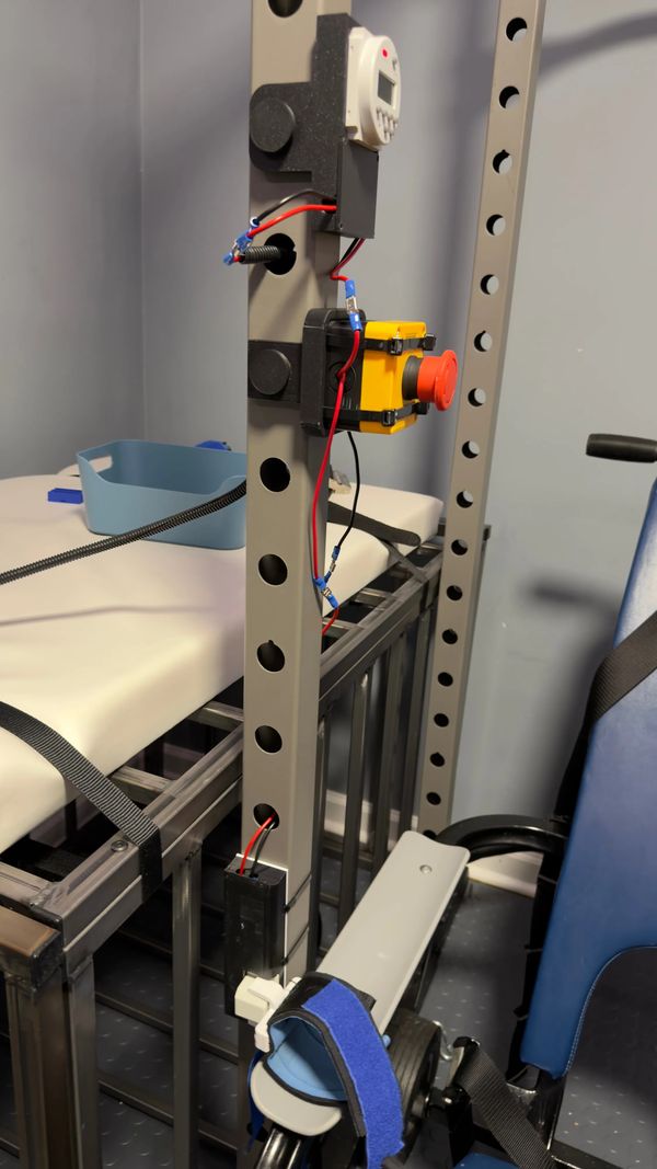 Overview of the set up. A digital timer, emergency stop button, and the solenoid attached to the post of a squat rack.