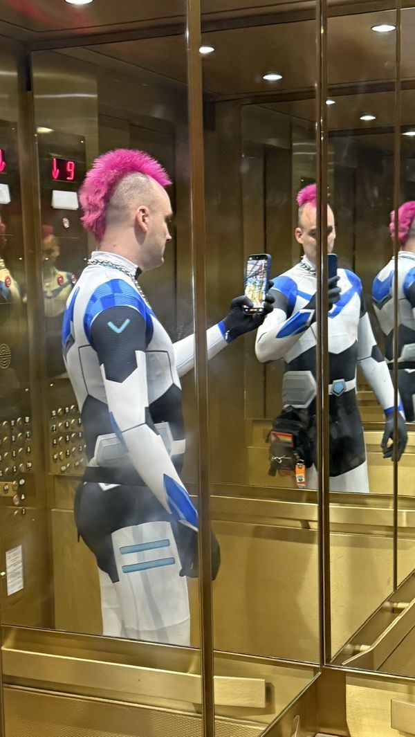 A mirror selfie of my pink mohawk. I am wearing a blue Voltron spandex suit