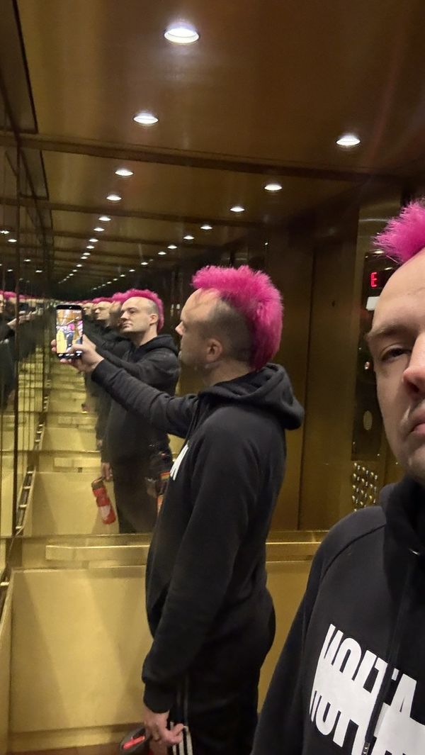 Another mirror selfie of my pink mohawk. I am wearing a black hoodie